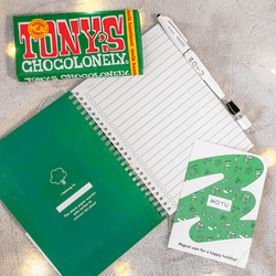 Top view of MOYU notebook, Tonys Chocolonely, and holiday card in MOYU Christmas Box
