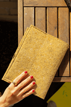 hand-picking-up-yellow-notebook-sleeve