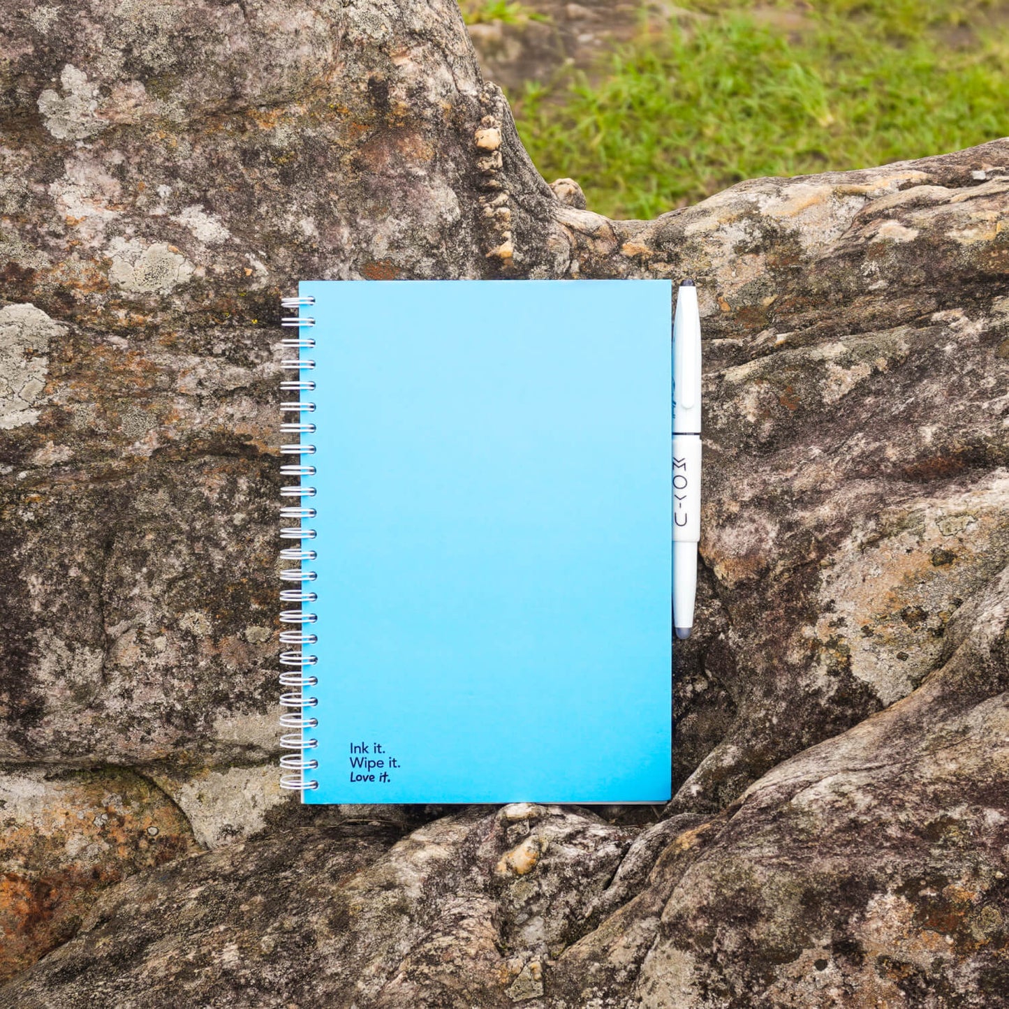 Sky Blue erasable notebook laying on rocks