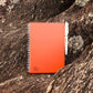 Erasable notebook Sunset Orange laying on rocks